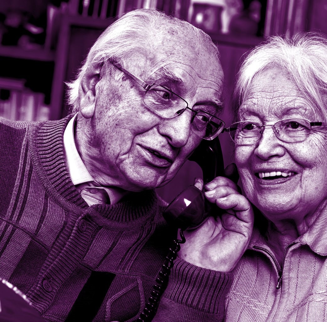 Two older people on the phone smiling